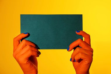 Boş kartı renk arka plan üzerinde tutan canavar