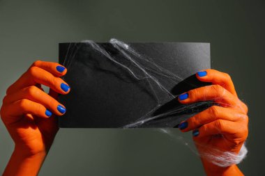 Boş kart koyu arka plan üzerinde tutan canavar