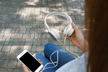 Hareket eden telefon ve kulaklık açık havada olan kadın