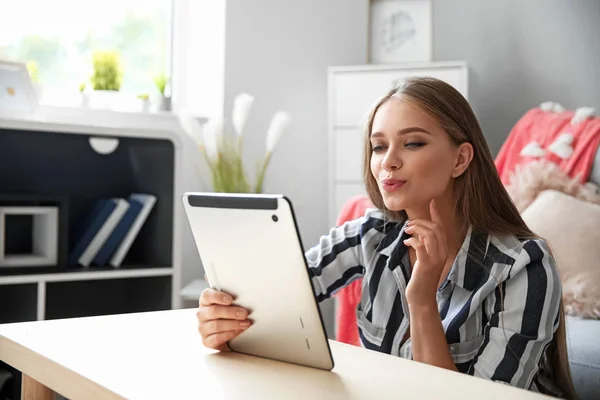 Jeune femme avec tablette informatique ayant en ligne sortir ensemble à la maison — Photo