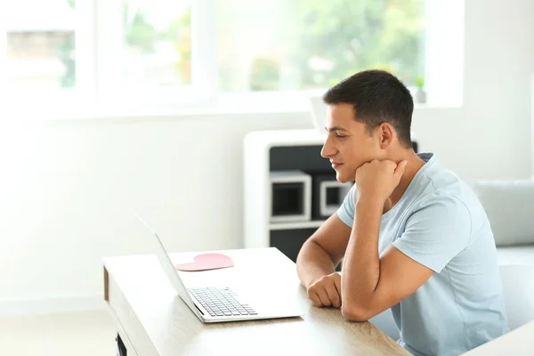 Hombre joven que tiene citas en línea en casa — Foto de Stock