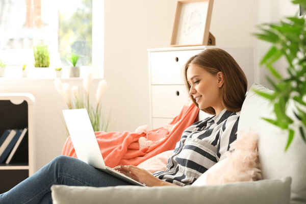 Молодая женщина работает на ноутбуке дома