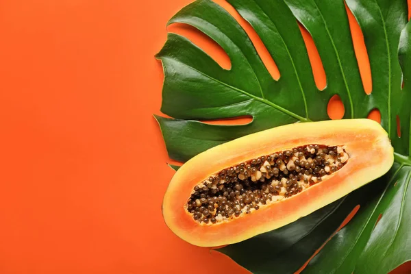 Hoja tropical y fruta madura sobre fondo de color —  Fotos de Stock