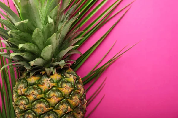 Reife Ananas und tropisches Blatt auf farbigem Hintergrund, Nahaufnahme — Stockfoto