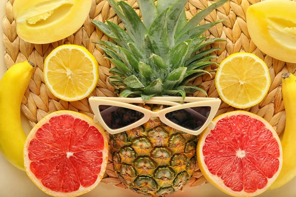 Летняя композиция с тропическими фруктами и солнечными очками на плетеном коврике — стоковое фото