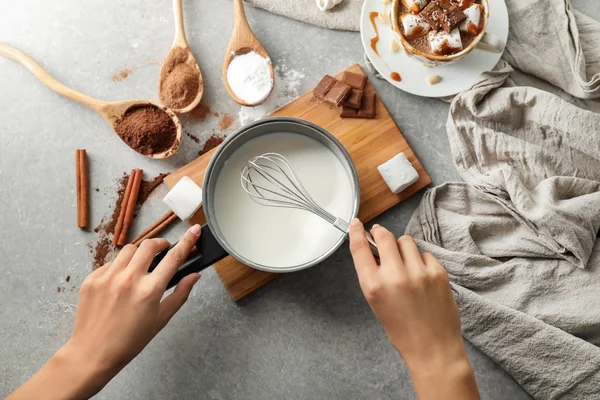 Woman preparing hot chocolate on grey table — Stock Photo, Image