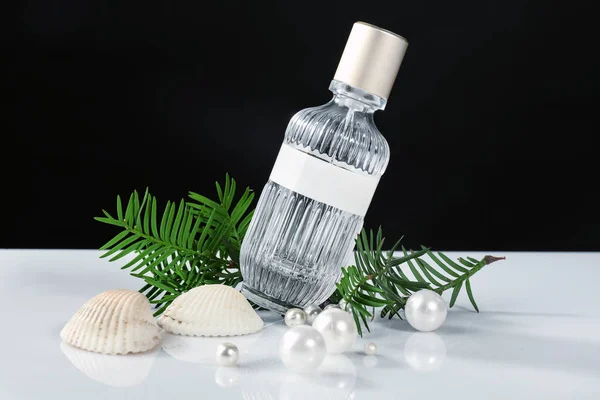 Üveg parfüm, a tengeri kagyló és a gyöngy, a táblázat ellen fekete háttér — Stock Fotó