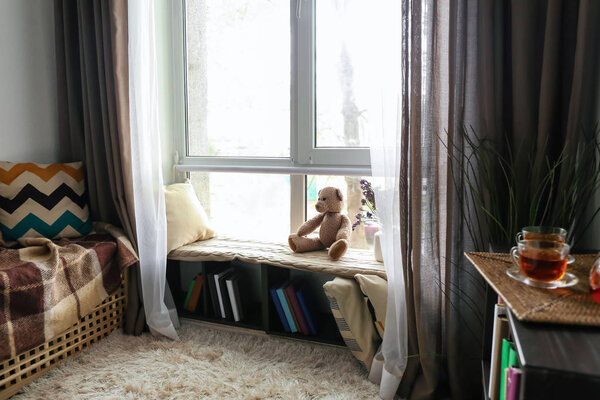 Cozy place for rest with book shelf near window in room