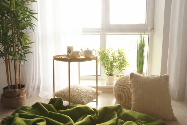 Lugar acolhedor para descansar com travesseiros e xadrez macio perto da janela no quarto — Fotografia de Stock
