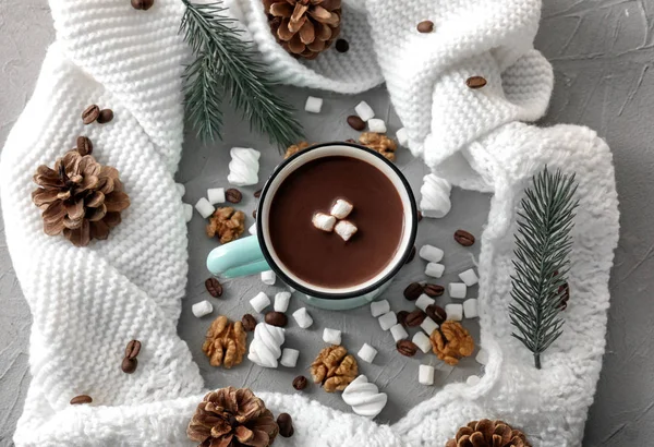 Металева чашка гарячого шоколаду з зефіром і теплим шарфом на сірому столі — стокове фото