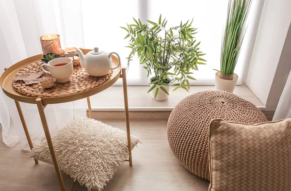 Cozy place for rest with cup of tea on table near window in room — Stock Photo, Image