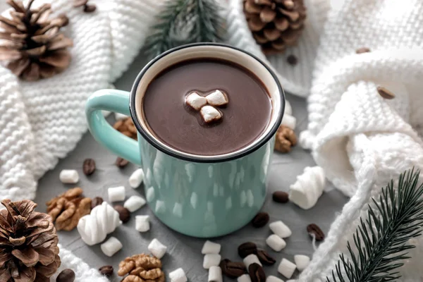 Metal cup of hot chocolate with marshmallows and warm scarf on grey table — Stock Photo, Image