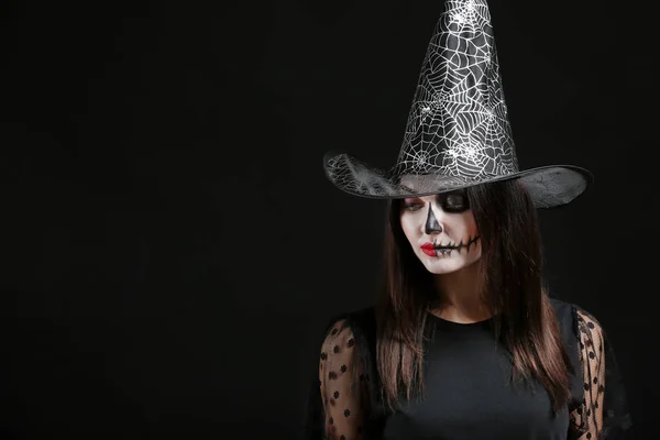 Krásná žena oblečená jako čarodějnice na Halloween na tmavém pozadí — Stock fotografie