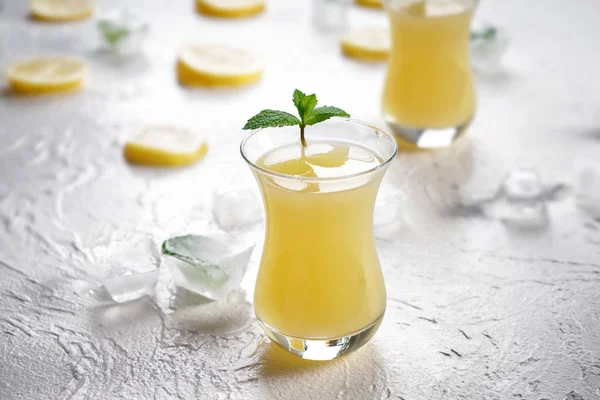 Vaso de zumo de limón fresco sobre mesa blanca — Foto de Stock