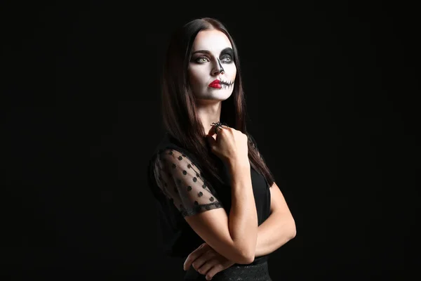 Schöne Frau zu Halloween auf dunklem Hintergrund gekleidet — Stockfoto