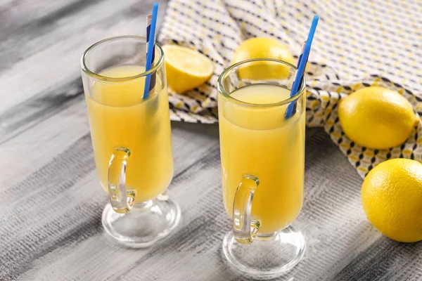 Окуляри свіжого лимонного соку на дерев'яному столі — стокове фото