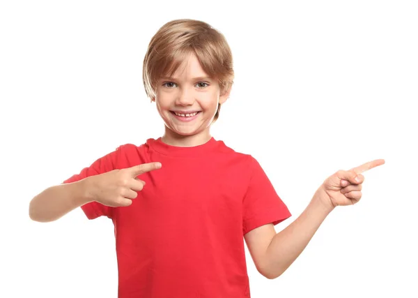 Niño con camiseta señalando algo sobre fondo blanco — Foto de Stock