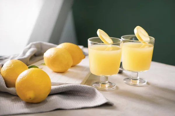 Glasses of fresh lemon juice on light table — Stock Photo, Image