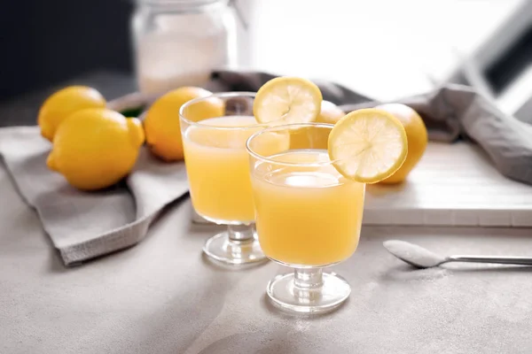 Glasögon av färsk citronsaft på ljusbordet — Stockfoto