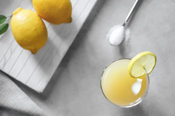 Glass of fresh lemon juice on light table — Stock Photo, Image