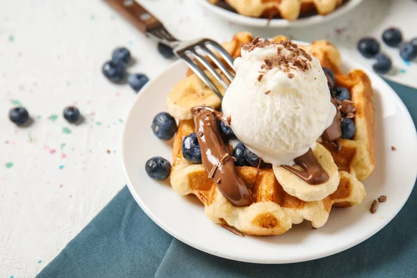 Delicious waffles with banana slices, blueberries and ice cream on plate — Stock Photo, Image