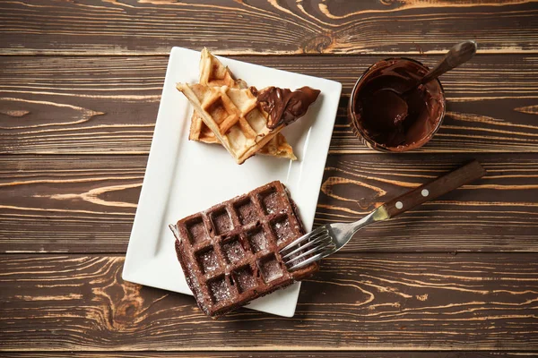 Deliciosos gofres con salsa de chocolate en la mesa de madera — Foto de Stock
