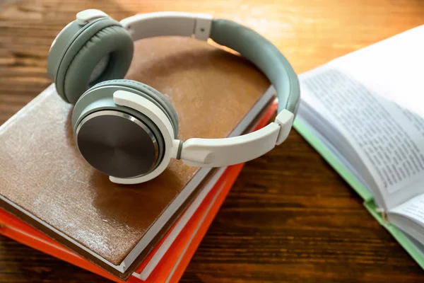 Modern headphones and books on wooden table. Concept of audiobook — Stock Photo, Image