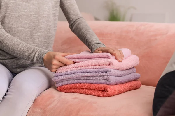 Kobieta, czystą, miękką ręczniki składane na kanapie w domu — Zdjęcie stockowe