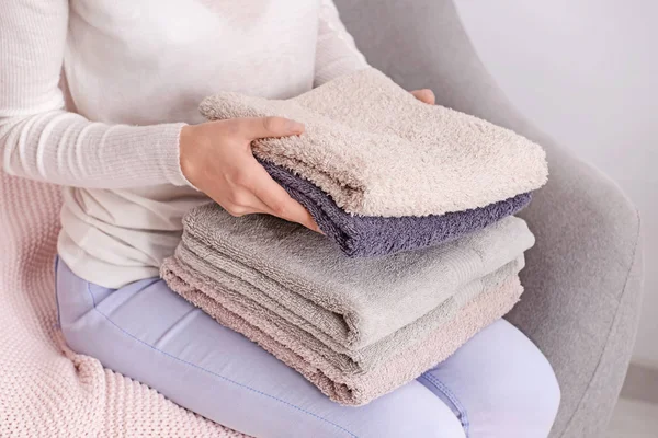 Жінка складає чисті м'які рушники на дивані вдома — стокове фото