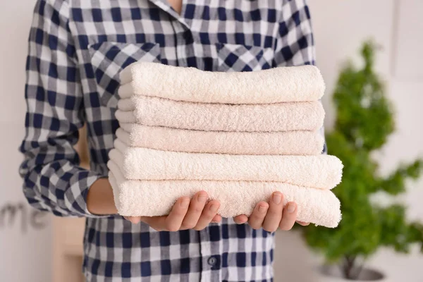 Woman holding stack of clean soft towels at home — Stock Photo, Image