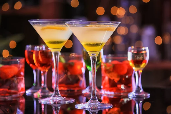 Свежие летние коктейли в стаканах на стеклянном столе — стоковое фото