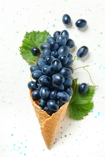 Вафельний конус з стиглим солодким виноградом на світлому фоні — стокове фото