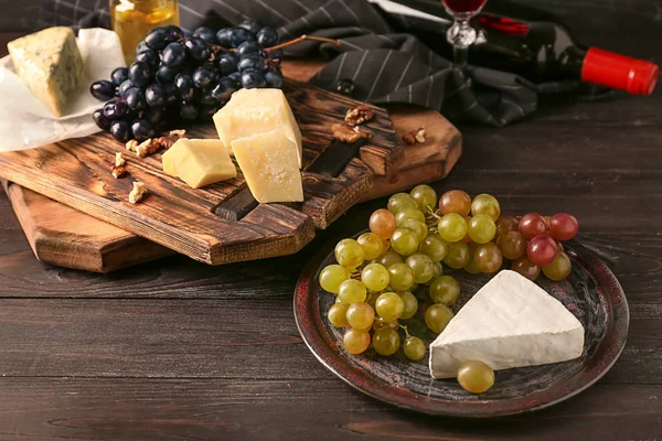 Uvas jugosas frescas maduras con queso sobre mesa de madera —  Fotos de Stock