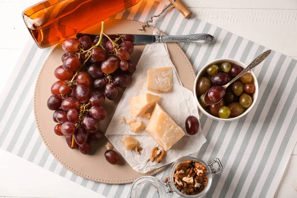 Сир і свіжий виноград з пляшкою вина на світлому столі — стокове фото