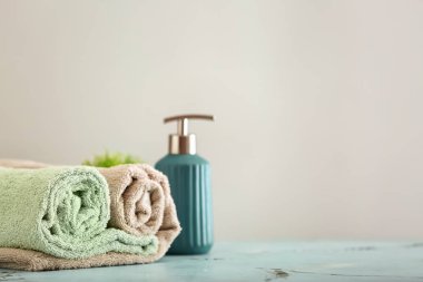 Temiz yumuşak havlu ve sabun dispenseri ışık arka plan üzerinde