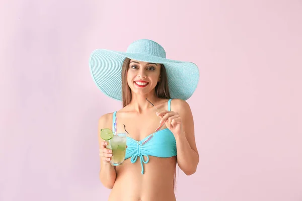 Piękna kobieta w strój kąpielowy i smaczny letni koktajl na kolor tła — Zdjęcie stockowe