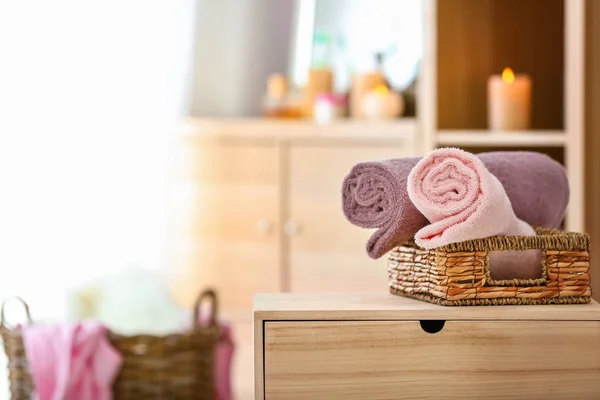 Weidenkorb mit sauberen weichen Handtüchern auf dem Tisch im Zimmer — Stockfoto