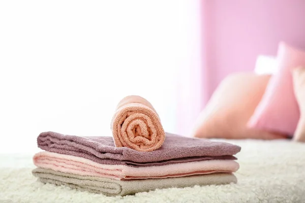 Stack of clean soft towels on bed — Stock Photo, Image