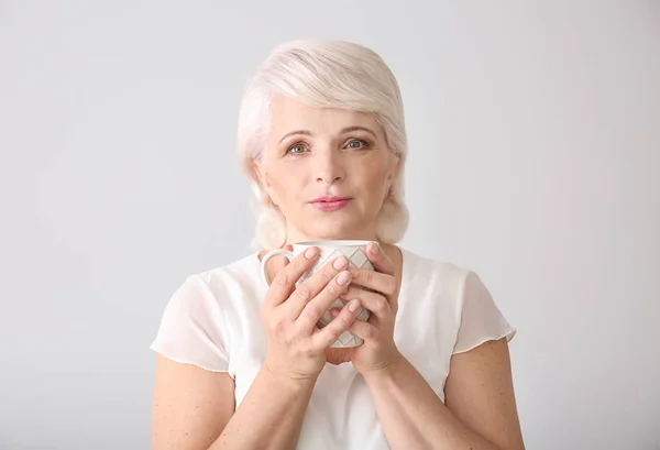 Hermosa mujer madura bebiendo café sobre fondo blanco — Foto de Stock