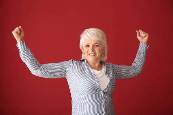 Porträtt av glad framgångsrika mogen kvinna på färg bakgrunden — Stockfoto