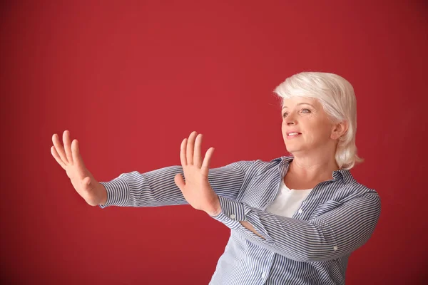 Porträt einer reifen Frau, die etwas auf farbigem Hintergrund ablehnt — Stockfoto