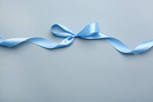Blaues Band mit Schleife auf farbigem Hintergrund — Stockfoto