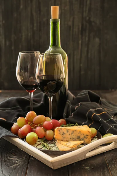 Спелый сочный виноград с сыром и красным вином на подносе — стоковое фото