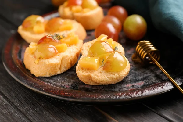 Tasty sandwiches with cheese, grape and honey on plate — Stock Photo, Image