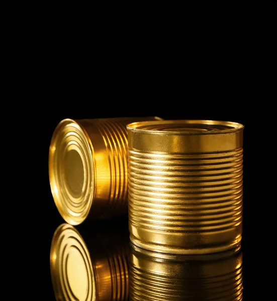 Latas de lata dourada em fundo preto — Fotografia de Stock