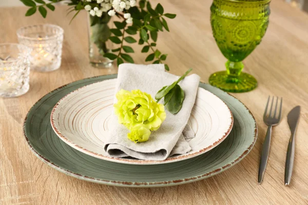 Beautiful festive table setting with floral decor on wooden background — Stock Photo, Image