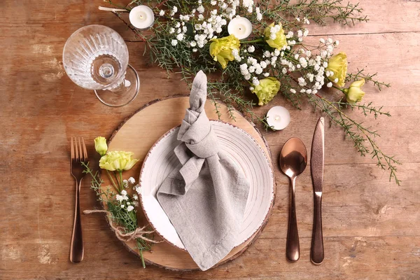 Beautiful festive table setting with floral decor on wooden background — Stock Photo, Image