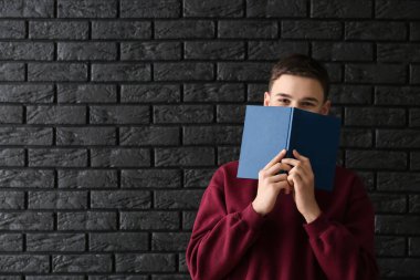 Koyu arka plan üzerine kitap ile öğrenci