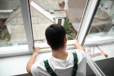 Genç bir işçi pencere dairede yükleme