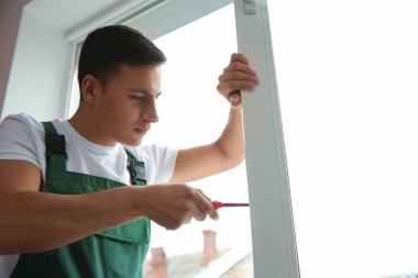 Genç bir işçi düz içinde pencere tamiri